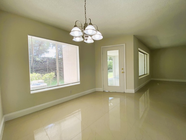 815 W Boynton Beach Blvd Unit 7-102, Boynton Beach, FL 33426 - unfurnished dining area with a chandelier, plenty of natural light, a textured ceiling, and tile patterned floors