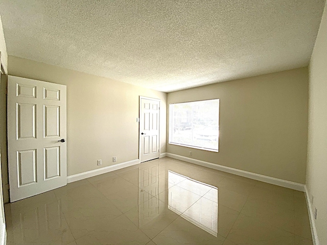 815 W Boynton Beach Blvd Unit 7-102, Boynton Beach, FL 33426 - spare room featuring a textured ceiling