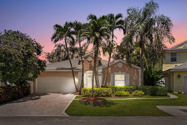 5210 NW 53rd Ave, Coconut Creek, FL 33073 - view of front of property with decorative driveway, an attached garage, a lawn, and stucco siding