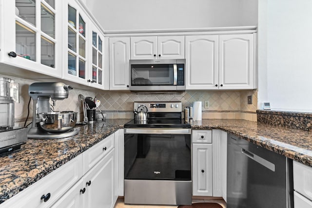5210 NW 53rd Ave, Coconut Creek, FL 33073 - kitchen featuring stainless steel appliances, white cabinetry, tasteful backsplash, and glass insert cabinets
