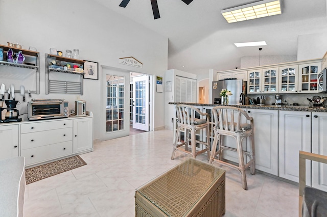 5210 NW 53rd Ave, Coconut Creek, FL 33073 - kitchen featuring appliances with stainless steel finishes, lofted ceiling, glass insert cabinets, a ceiling fan, and a kitchen breakfast bar