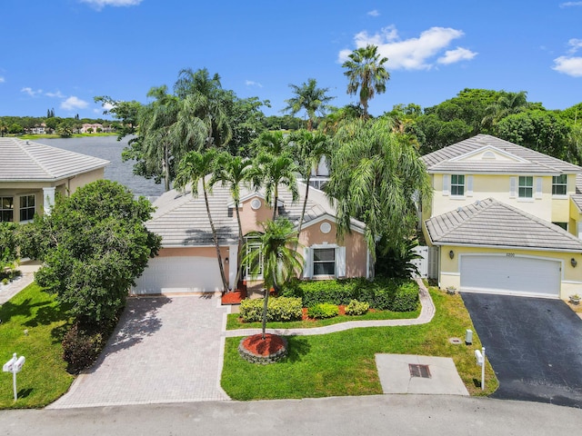 5210 NW 53rd Ave, Coconut Creek, FL 33073 - view of front of home with driveway, a tiled roof, stucco siding, and a front lawn