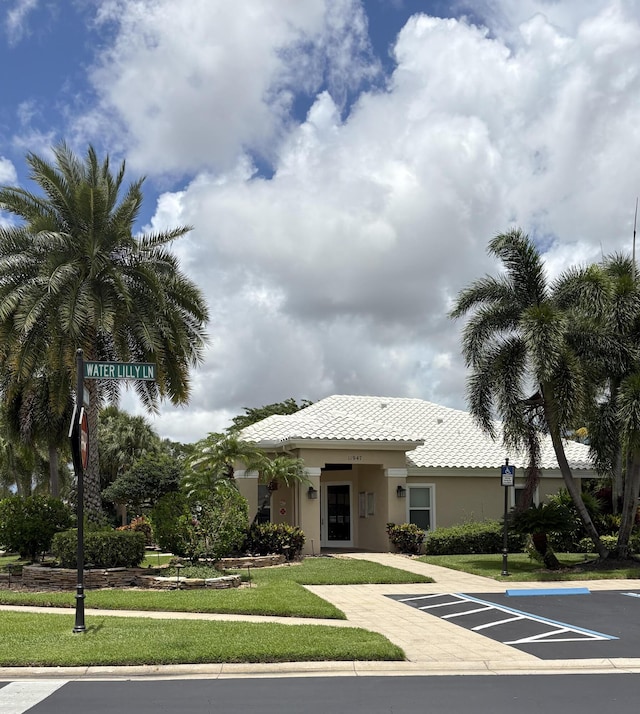 6314 Water Lilly Ln, Boynton Beach, FL 33437 - view of front of house with a front lawn, a tile roof, uncovered parking, and stucco siding