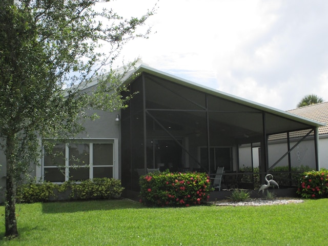 6314 Water Lilly Ln, Boynton Beach, FL 33437 - back of property featuring a yard, stucco siding, and glass enclosure