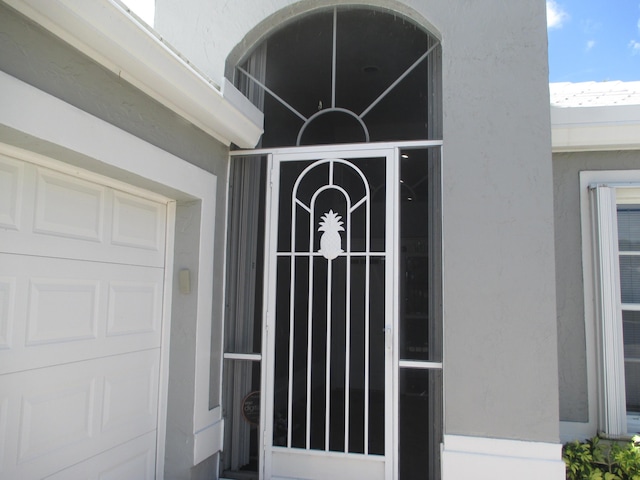 6314 Water Lilly Ln, Boynton Beach, FL 33437 - doorway to property featuring stucco siding and a garage