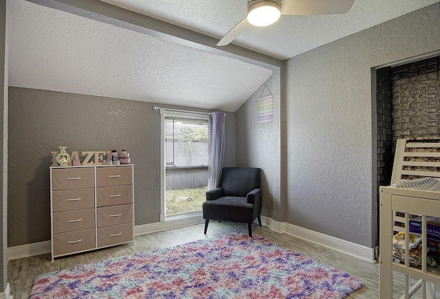 372 NE Ardsley Dr, Port Saint Lucie, FL 34983 - sitting room featuring a textured wall, a textured ceiling, vaulted ceiling, wood finished floors, and a ceiling fan