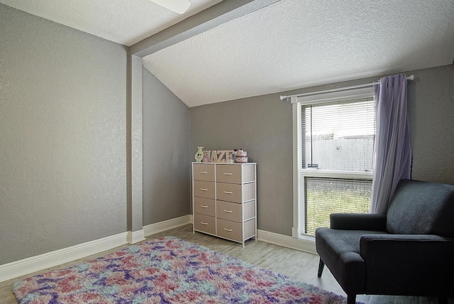 372 NE Ardsley Dr, Port Saint Lucie, FL 34983 - living area with wood finished floors, a textured wall, a textured ceiling, and lofted ceiling
