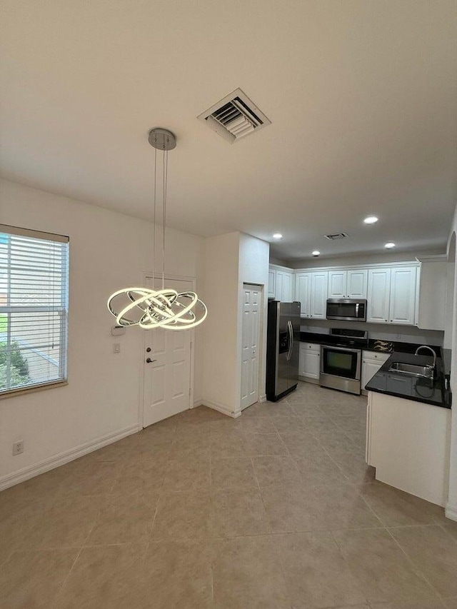 108 W Pigeon Plum Dr W Unit 102, Jupiter, FL 33458 - kitchen with stainless steel appliances, dark countertops, white cabinetry, recessed lighting, and light tile patterned flooring