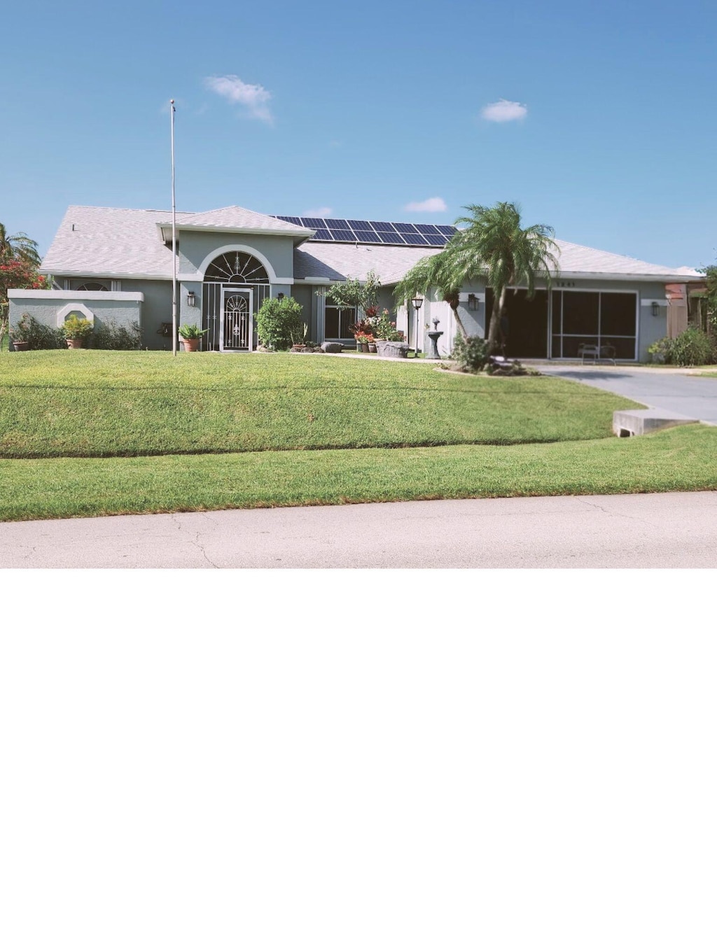 1341 SW Abingdon Ave, Port Saint Lucie, FL 34953 - single story home with roof mounted solar panels, a front yard, driveway, and stucco siding