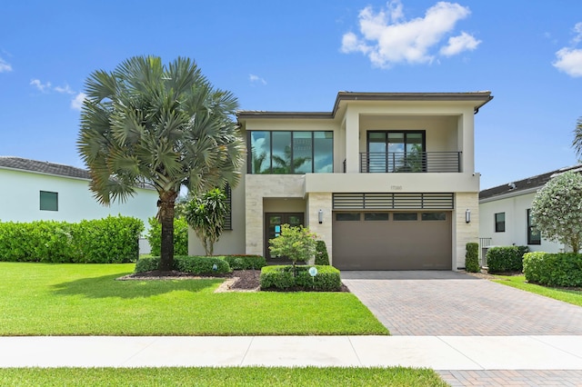 17380 Rainstream Rd, Boca Raton, FL 33496 - view of front of house featuring a balcony, decorative driveway, stucco siding, a garage, and a front yard