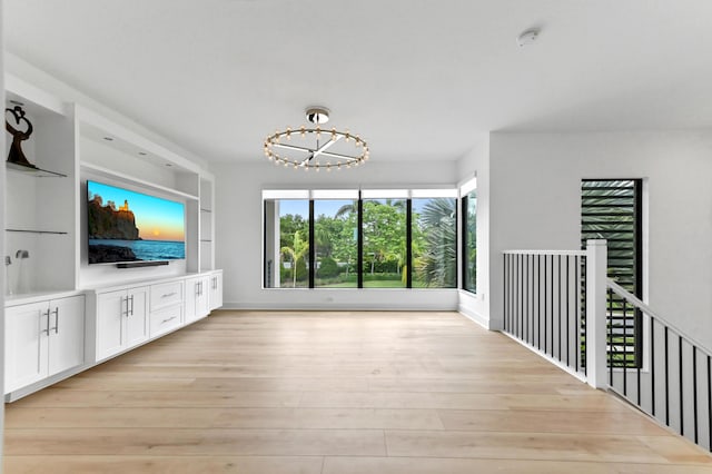 17380 Rainstream Rd, Boca Raton, FL 33496 - unfurnished living room featuring light wood-style flooring, a chandelier, and built in features