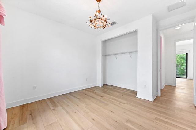 17380 Rainstream Rd, Boca Raton, FL 33496 - unfurnished bedroom with light wood-type flooring, a chandelier, and a closet