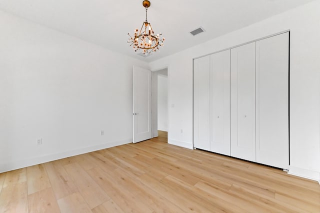 17380 Rainstream Rd, Boca Raton, FL 33496 - unfurnished bedroom featuring a chandelier, light wood-style floors, and a closet