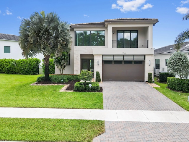 17380 Rainstream Rd, Boca Raton, FL 33496 - view of front of property featuring a balcony, stucco siding, decorative driveway, a garage, and a front yard