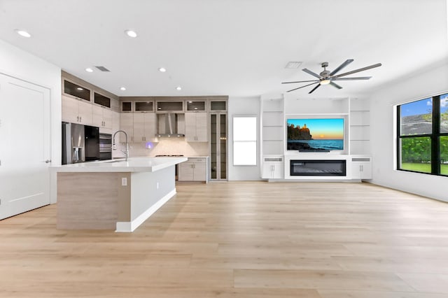 17380 Rainstream Rd, Boca Raton, FL 33496 - kitchen with appliances with stainless steel finishes, wall chimney exhaust hood, light countertops, a ceiling fan, and a center island with sink