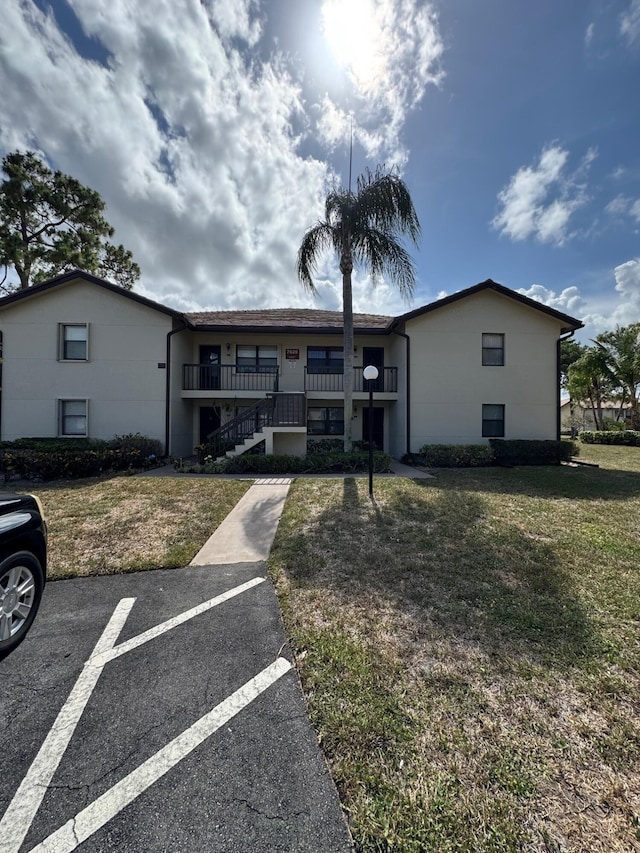 7626 Tahiti Ln Unit 204, Lake Worth, FL 33467 - view of front facade featuring a front lawn, uncovered parking, and stairs