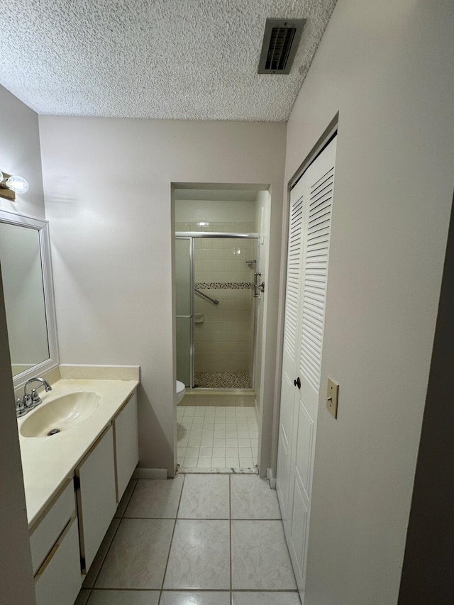 7626 Tahiti Ln Unit 204, Lake Worth, FL 33467 - full bath featuring vanity, a stall shower, a closet, tile patterned flooring, and a textured ceiling