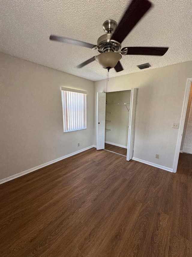 7626 Tahiti Ln Unit 204, Lake Worth, FL 33467 - unfurnished bedroom featuring a textured ceiling, dark wood-type flooring, a closet, and ceiling fan
