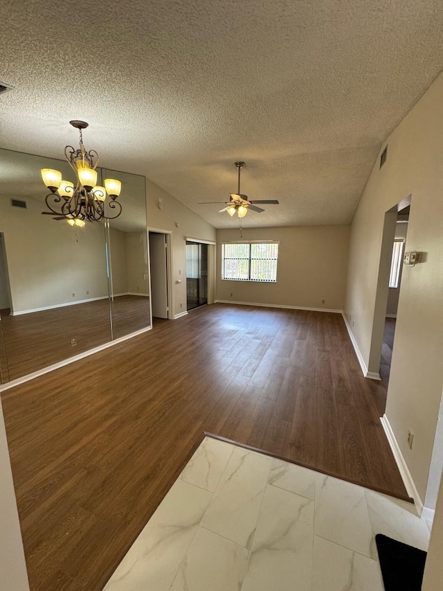 7626 Tahiti Ln Unit 204, Lake Worth, FL 33467 - unfurnished living room with vaulted ceiling, a textured ceiling, ceiling fan, wood finished floors, and a chandelier