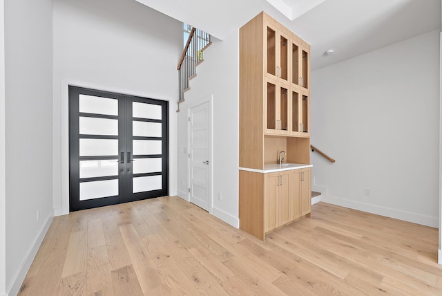 295 Austin Ln, West Palm Beach, FL 33401 - foyer with french doors, light wood finished floors, a towering ceiling, and stairway