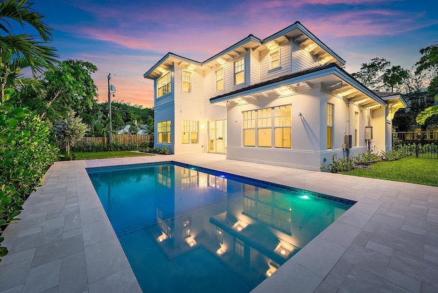 295 Austin Ln, West Palm Beach, FL 33401 - back of house at dusk featuring a patio area and stucco siding