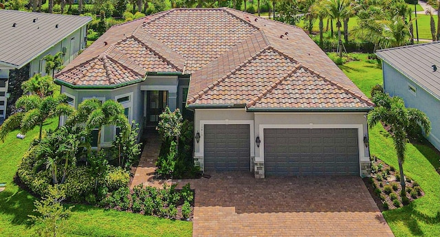 10815 Stellar Cir, Palm Beach Gardens, FL 33412 - mediterranean / spanish-style home with a tiled roof, an attached garage, stucco siding, and decorative driveway