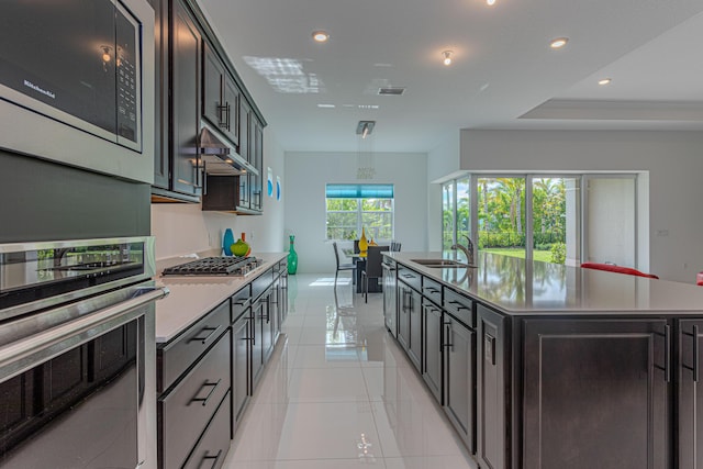 10815 Stellar Cir, Palm Beach Gardens, FL 33412 - kitchen with stainless steel appliances, light countertops, a large island with sink, recessed lighting, and light tile patterned floors