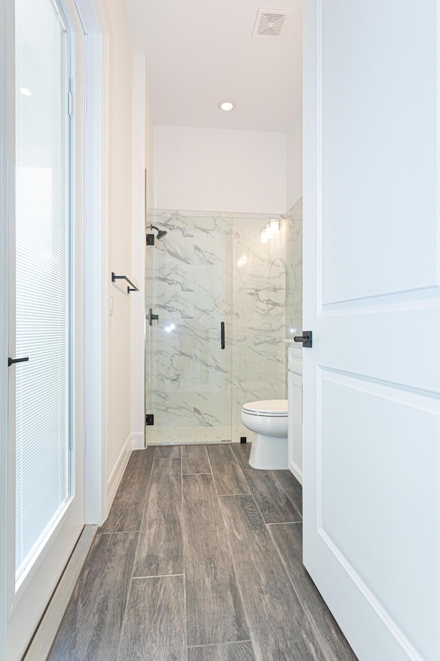 10815 Stellar Cir, Palm Beach Gardens, FL 33412 - bathroom featuring a marble finish shower, wood finished floors, and recessed lighting