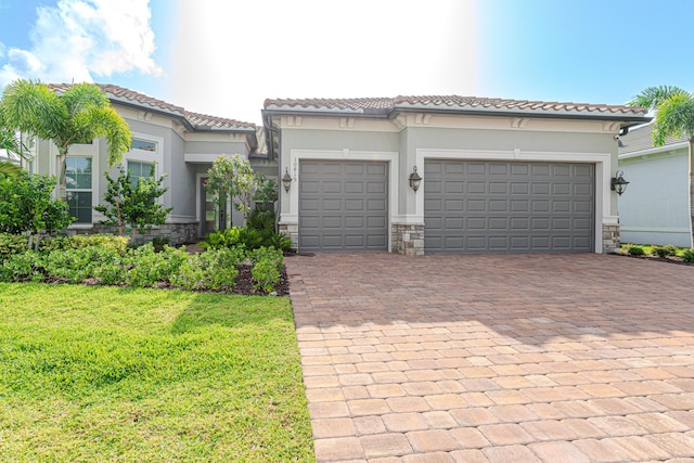 10815 Stellar Cir, Palm Beach Gardens, FL 33412 - mediterranean / spanish-style house featuring decorative driveway, an attached garage, stucco siding, and stone siding