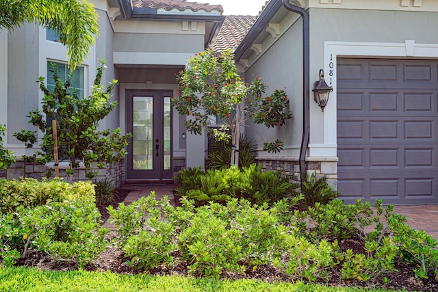 10815 Stellar Cir, Palm Beach Gardens, FL 33412 - doorway to property featuring stone siding, a garage, and stucco siding