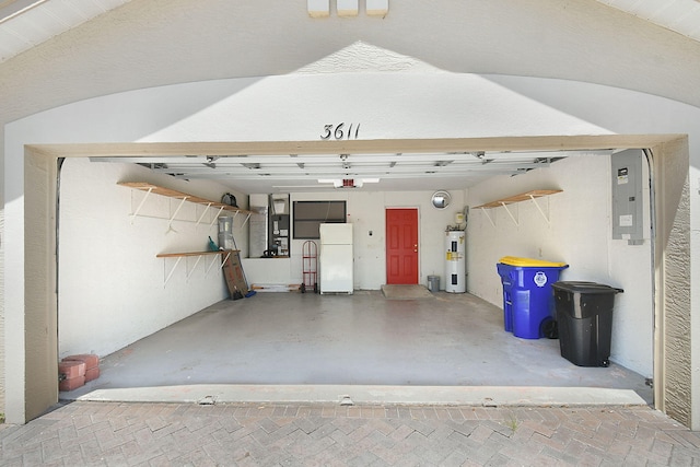 3611 NW Willow Creek Dr, Jensen Beach, FL 34957 - garage featuring water heater, freestanding refrigerator, and a garage door opener