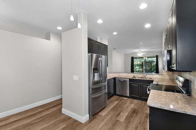 3611 NW Willow Creek Dr, Jensen Beach, FL 34957 - kitchen with stainless steel appliances, light wood-style flooring, tasteful backsplash, light stone countertops, and ceiling fan