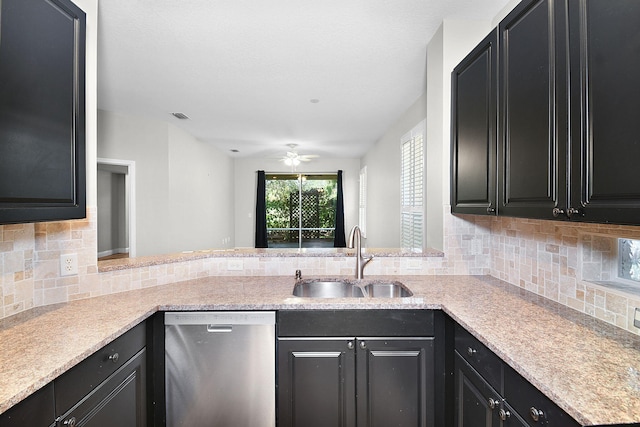 3611 NW Willow Creek Dr, Jensen Beach, FL 34957 - kitchen with stainless steel dishwasher, dark cabinets, a ceiling fan, decorative backsplash, and a peninsula