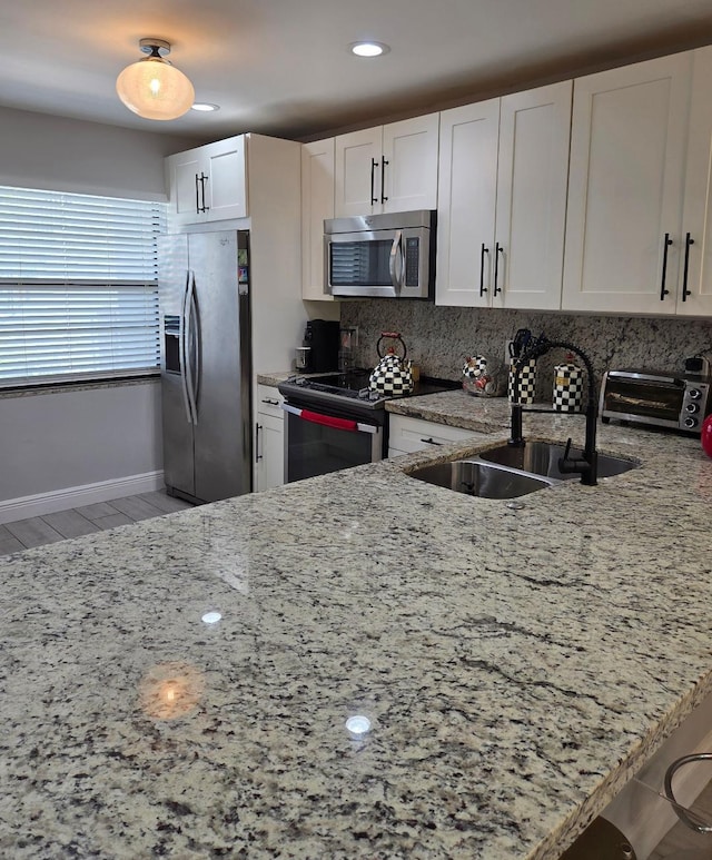 21404 Cypress Hammock Dr Unit 45E, Boca Raton, FL 33428 - kitchen featuring stainless steel appliances, light stone countertops, backsplash, white cabinetry, and light wood-style floors