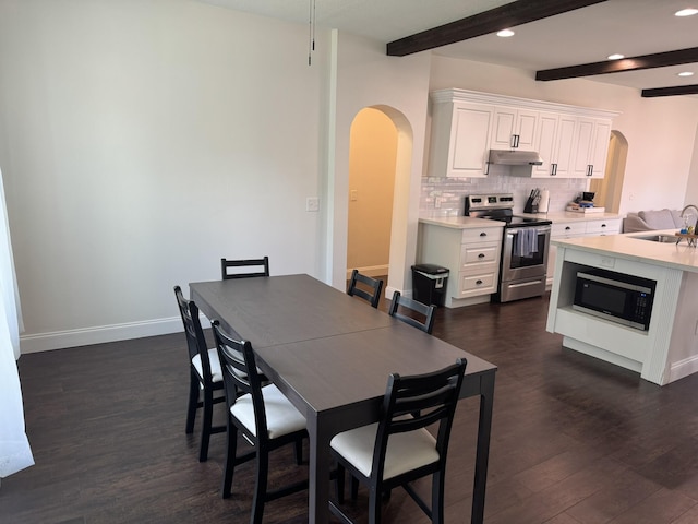 639 38th St, West Palm Beach, FL 33407 - dining area featuring arched walkways, dark wood-style floors, beam ceiling, and recessed lighting