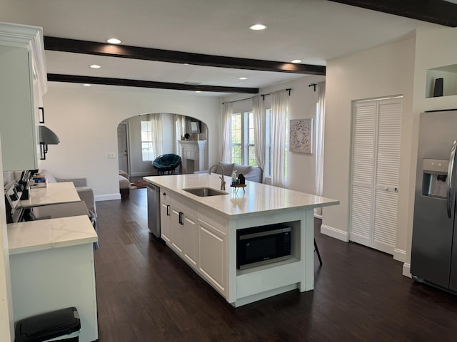 639 38th St, West Palm Beach, FL 33407 - kitchen featuring appliances with stainless steel finishes, arched walkways, open floor plan, dark wood-style flooring, and light stone countertops