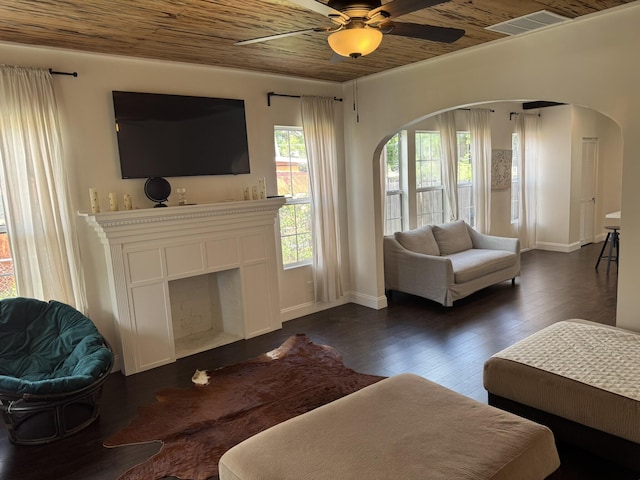 639 38th St, West Palm Beach, FL 33407 - living room featuring ceiling fan, dark wood-type flooring, arched walkways, and a fireplace with flush hearth