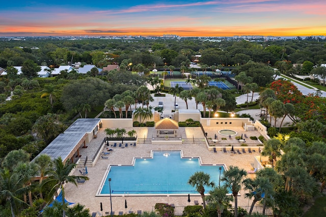 348 River Edge Rd, Jupiter, FL 33477 - pool at dusk featuring view of scattered trees and a community pool