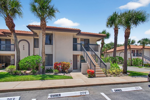 400 Club Cir Unit 201, Boca Raton, FL 33487 - view of property featuring stairs and uncovered parking