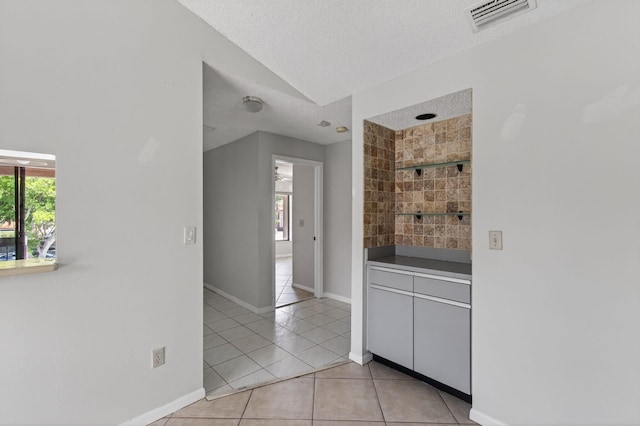 400 Club Cir Unit 201, Boca Raton, FL 33487 - bar featuring light tile patterned flooring, healthy amount of natural light, lofted ceiling, and a textured ceiling