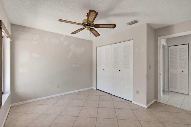 400 Club Cir Unit 201, Boca Raton, FL 33487 - unfurnished bedroom with light tile patterned floors, a textured ceiling, a closet, and a ceiling fan