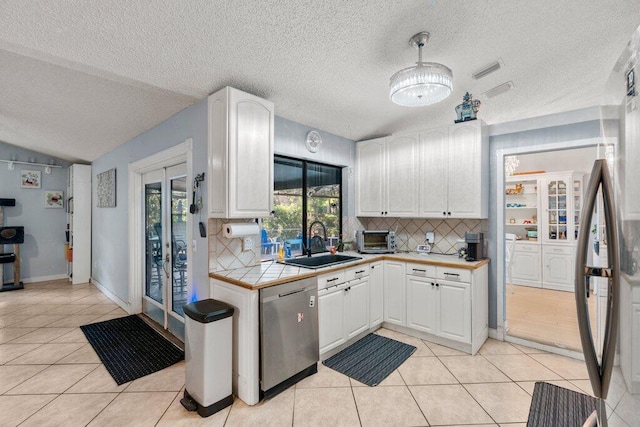 2997 SW Collings Dr, Port Saint Lucie, FL 34953 - kitchen with stainless steel appliances, light tile patterned floors, tasteful backsplash, a textured ceiling, and vaulted ceiling