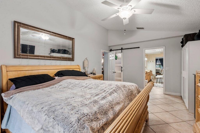 2997 SW Collings Dr, Port Saint Lucie, FL 34953 - bedroom with lofted ceiling, a barn door, a textured ceiling, light tile patterned flooring, and a ceiling fan