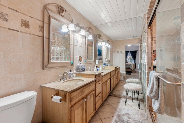 2997 SW Collings Dr, Port Saint Lucie, FL 34953 - ensuite bathroom with double vanity, tile patterned flooring, and tile walls
