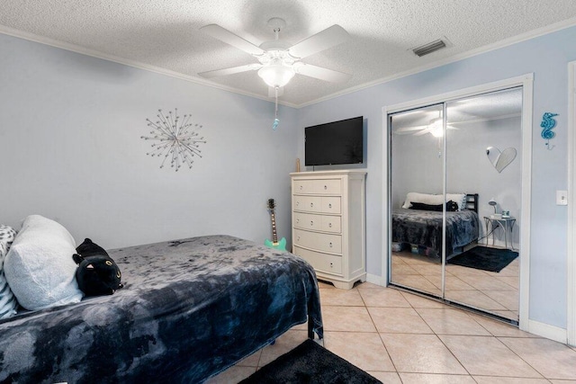2997 SW Collings Dr, Port Saint Lucie, FL 34953 - bedroom featuring light tile patterned flooring, crown molding, a textured ceiling, ceiling fan, and a closet