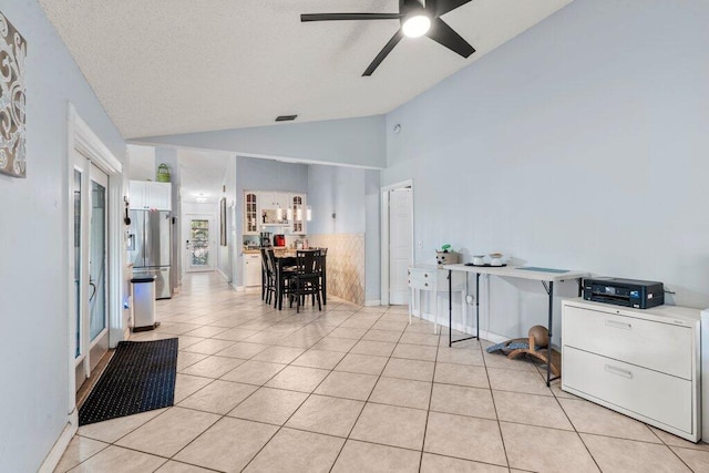 2997 SW Collings Dr, Port Saint Lucie, FL 34953 - dining room with vaulted ceiling, light tile patterned floors, a ceiling fan, and a textured ceiling