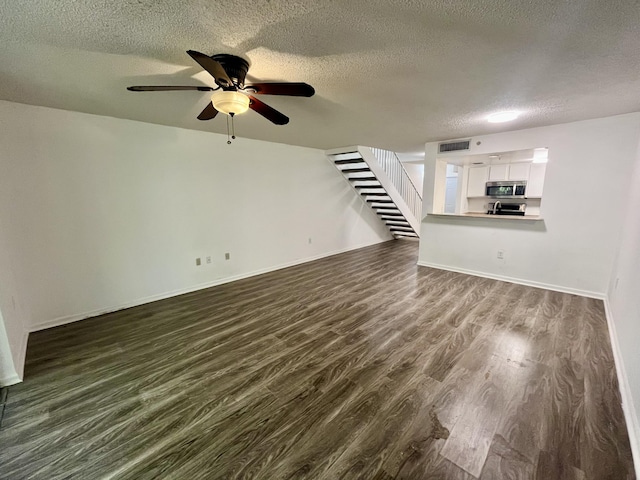 1100 Scotia Dr Unit 102, Hypoluxo, FL 33462 - unfurnished living room with a textured ceiling, stairway, dark wood-style floors, and ceiling fan