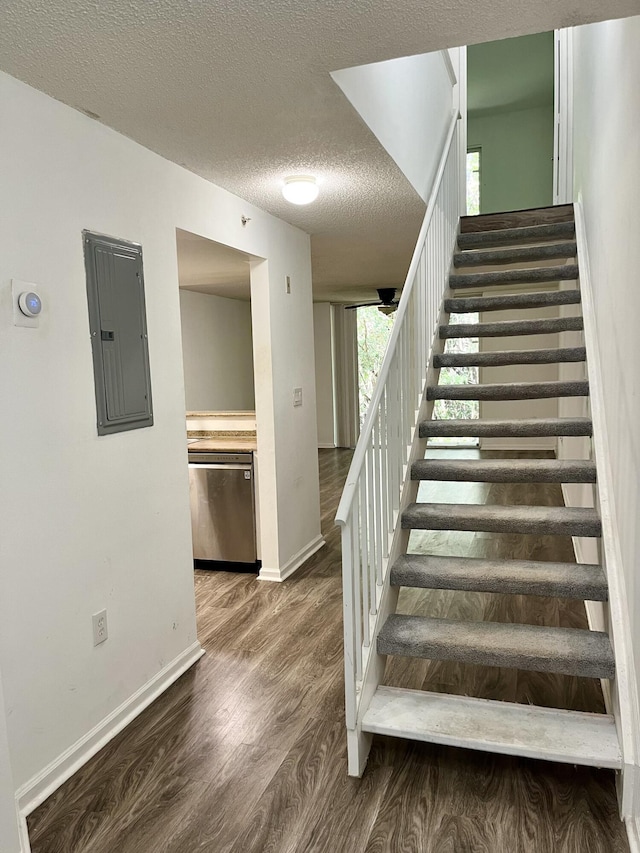 1100 Scotia Dr Unit 102, Hypoluxo, FL 33462 - staircase featuring electric panel, wood finished floors, and a textured ceiling