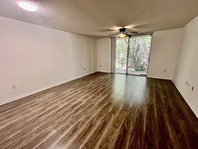 1100 Scotia Dr Unit 102, Hypoluxo, FL 33462 - spare room with a textured ceiling, a ceiling fan, dark wood-style floors, and a wall of windows