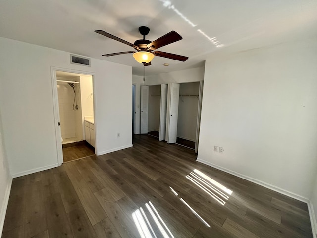 1100 Scotia Dr Unit 102, Hypoluxo, FL 33462 - unfurnished bedroom featuring dark wood-type flooring, two closets, ensuite bath, and a ceiling fan